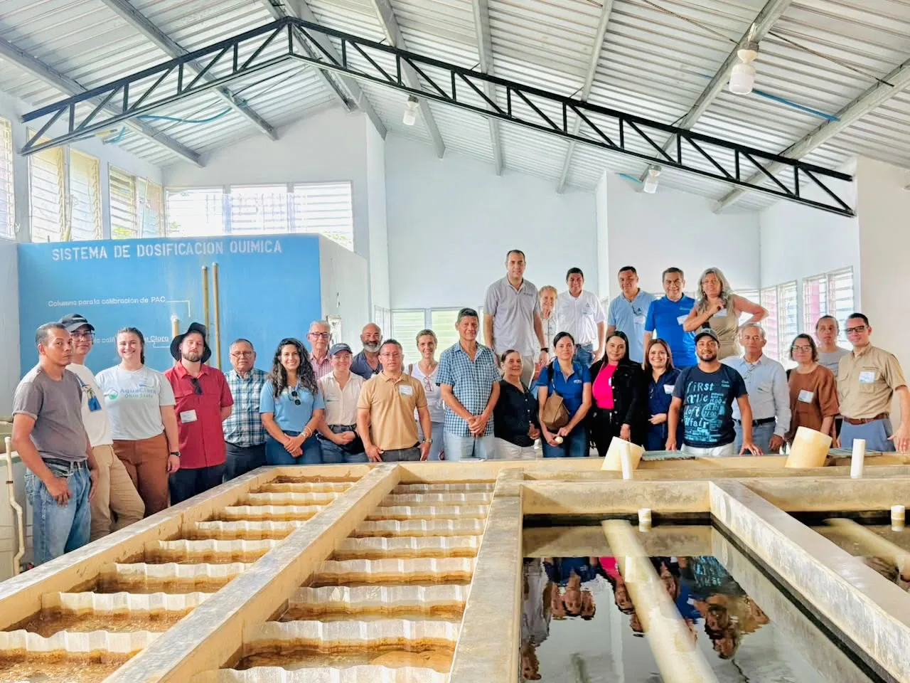 Participantes del Diálogo Global de Liderazgo posan junto a los tanques de una planta de tratamiento de agua AguaClara