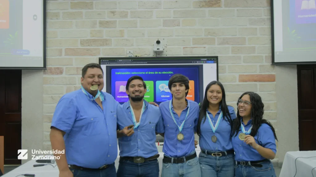 Equipo de estudiantes celebra con sus medallas junto a un docente en las Olimpiadas del Conocimiento 2026