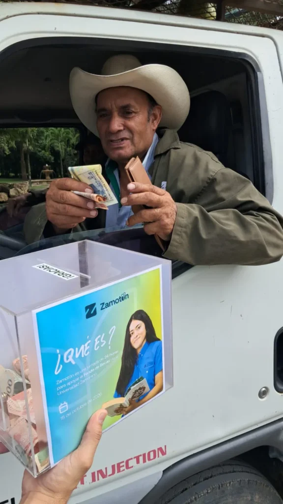 Colaborador de Universidad Zamorano muestra su donación desde un vehículo junto a la caja de Zamotón 2026